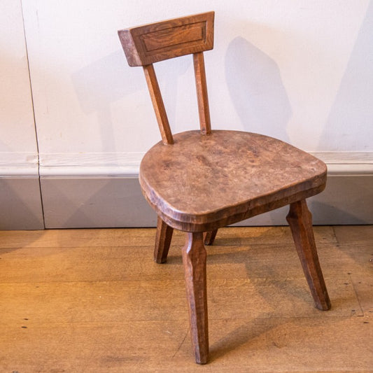A SMALL LOW SOPHISTICATED RUSTIC CARVED CHAIR BY JACK GRIMBLE