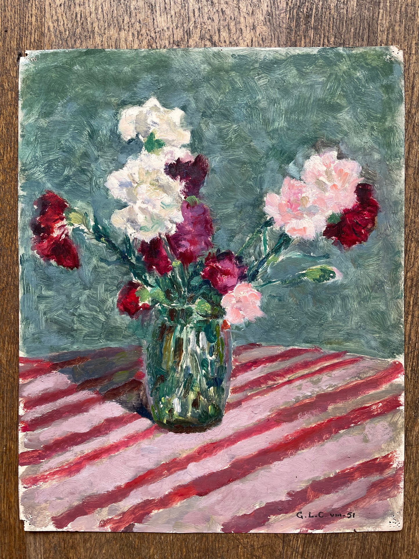 CARNATIONS IN A GREEN VASE ON A PINK STRIPED TABLECLOTH