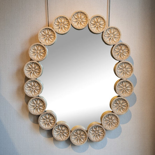 A LARGE OVAL MIRROR WITH CARVED ROUNDELS