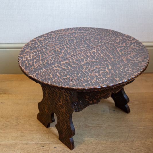 A SMALL LOW OVAL TABLE WITH ADZED FINISH