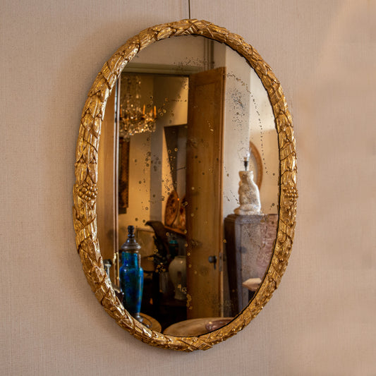 CARVED AND GILTWOOD OVAL MIRROR OF UNUSUAL DESIGN