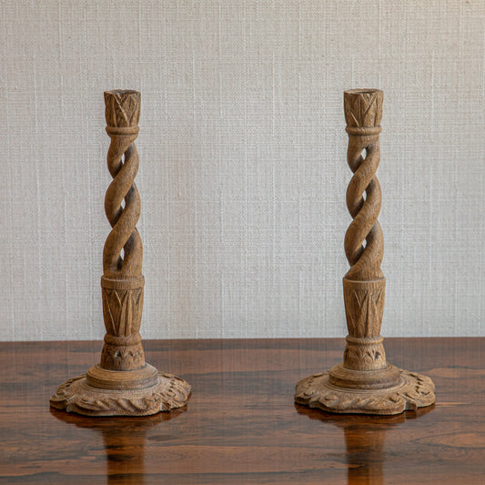 A PAIR OF FADED OAK CANDLESTICKS WITH SPIRALLY TWISTED STEM AND PETAL BASES