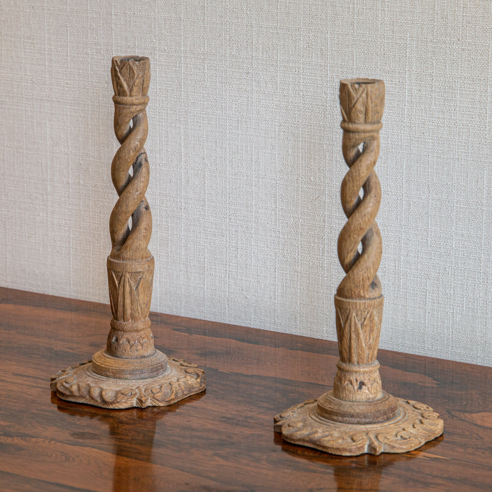 A PAIR OF FADED OAK CANDLESTICKS WITH SPIRALLY TWISTED STEM AND PETAL BASES